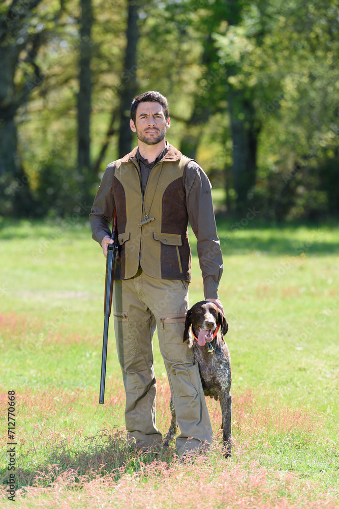 portrait of hunter with dog outdoors