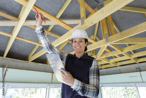 female contractor pointing to wooden beams