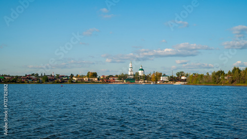 a beautiful blue lake with a village and a church on the horizon