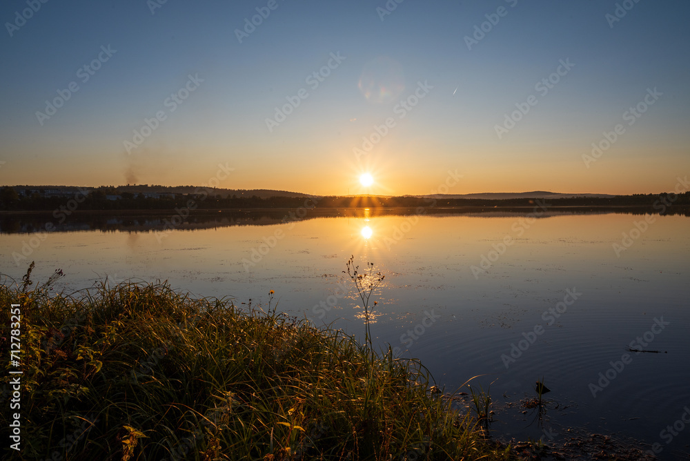 a beautiful warm sunset and a picturesque landscape with a lake a beautiful warm sunset and a picturesque landscape with a lake