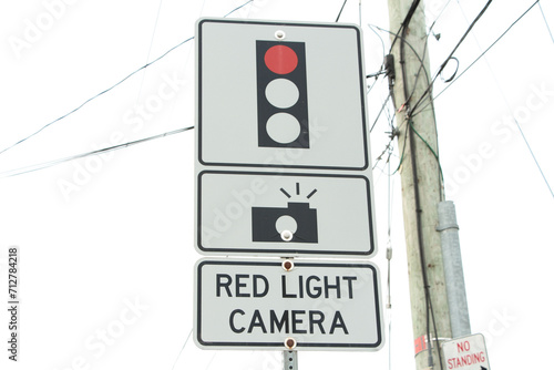 red light camera text sign with three atop each other with illustration of picture camera and red traffic light on metal post