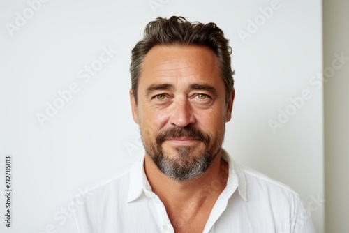 Portrait of a handsome mature man with beard and mustache in white shirt