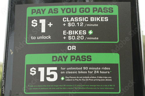 toronto rent a bike or e-bike rates and instructions on pay meter in green and white print on black background, pay as you go or day pass - close shot