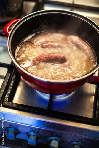 Carniolan Sausages in a Pot Boiling on Kitchen Oven Fire