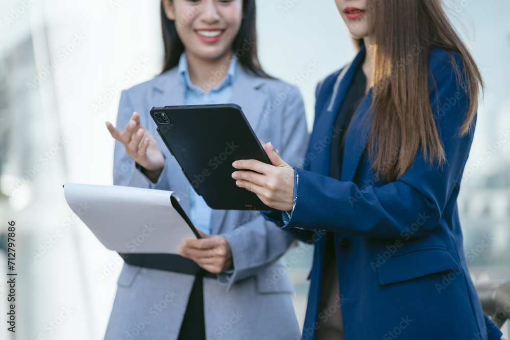 Portrait of two stylish pretty women standing and holding laptop and mobile phones. Portrait of two stylish pretty women standing and holding laptop and mobile phones.