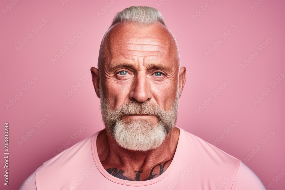 Portrait of a senior man with grey hair and beard on a pink background. Portrait of a senior man with grey hair and beard on a pink background.