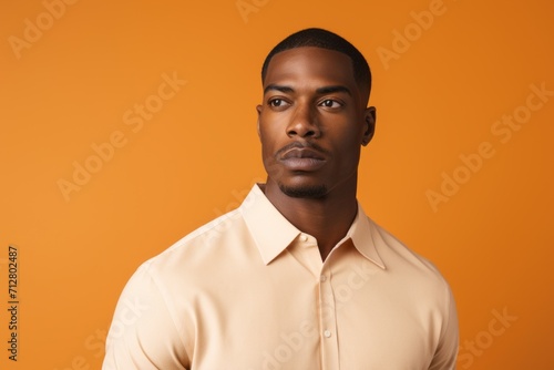 Serious african american man looking at camera on orange background