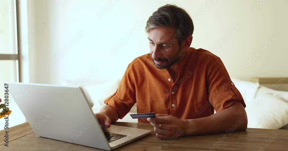 Mature man make on-line purchase enters card data pay bills through secure e-bank system, using easy, quick money transfer websites, ordering goods remotely. Electronic commerce client do e-shopping