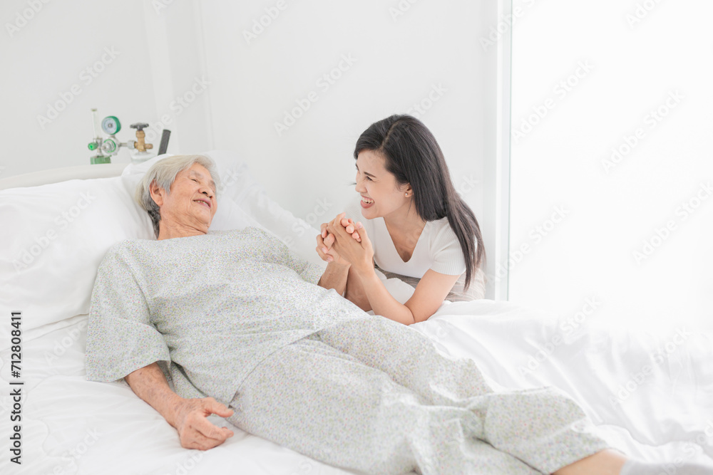 old asian patient sick and admit in hospital, young asian female visiting old female, they holding hands together, they feeling happy and smile in mother's day, elderly healthcare old asian patient sick and admit in hospital, young asian female visiting old female, they holding hands together, they feeling happy and smile in mother's day, elderly healthcare