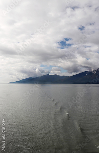 Sky scape with clouds over distant shore from the ocean.