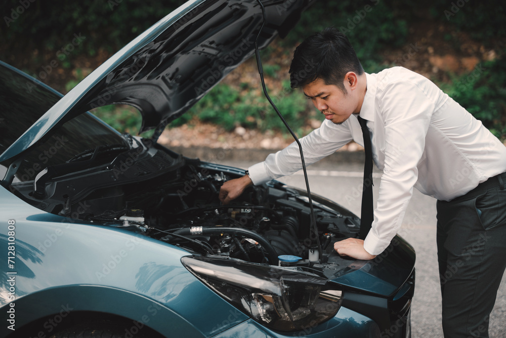 Asian businessman car broken breakdown, angry young stressed man stands trouble car failure problem looking in frustration at failed engine in morning, accident on road outdoor, late for business work Asian businessman car broken breakdown, angry young stressed man stands trouble car failure problem looking in frustration at failed engine in morning, accident on road outdoor, late for business work