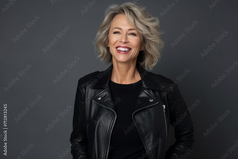Portrait of a happy senior woman in leather jacket on grey background Portrait of a happy senior woman in leather jacket on grey background