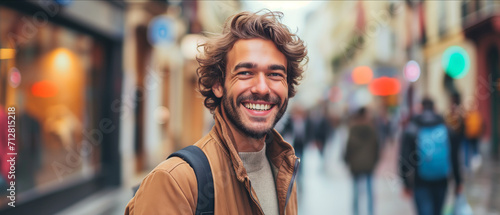 Joyful Young Man with Curly Hair and a Charming Smile Enjoying His Day in a Bustling City Street