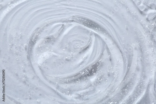 Clear cosmetic serum on white background, macro view