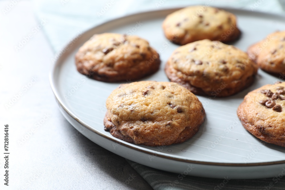 Plate with delicious chocolate chip cookies on table, closeup Plate with delicious chocolate chip cookies on table, closeup