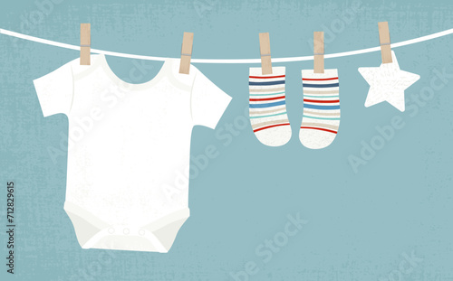 Baby boy clothes pinned to a clothesline, in a cut paper style with textures
