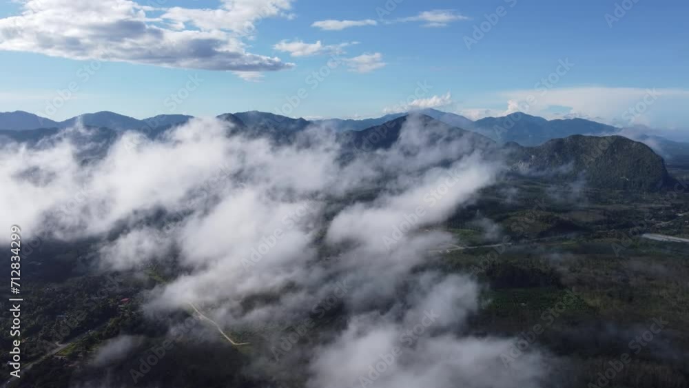 Bird's-eye view revealing the mystical allure of Baling hill shrouded in gentle, low-lying clouds Bird's-eye view revealing the mystical allure of Baling hill shrouded in gentle, low-lying clouds