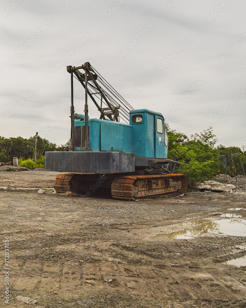 a broken and rusty mobile crane from behind. a broken and rusty mobile crane from behind.
