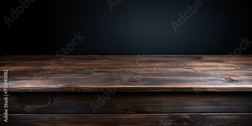 Dark wooden tabletop on black background, suitable for displaying or showcasing your products.