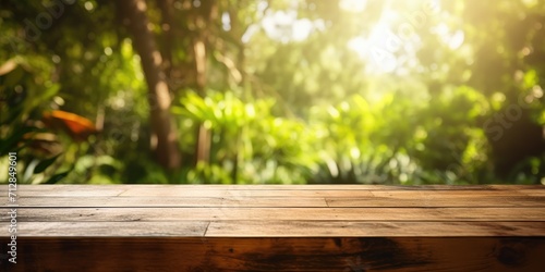 Wooden table with blurred garden trees and sunlight  used for displaying products.