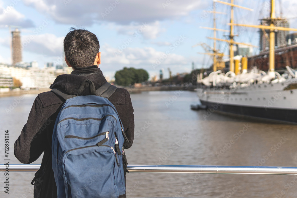 Back view of a tourist posing in front of a boat in Puerto Madero, Buenos Aires, Argentina Back view of a tourist posing in front of a boat in Puerto Madero, Buenos Aires, Argentina