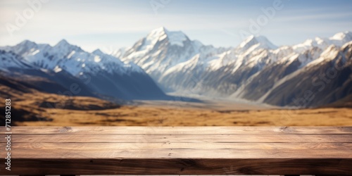 Mount Cook landscape with blurred background on empty wooden brown table top. Exuberant image.