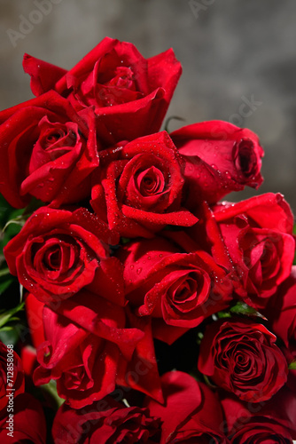 bouquet of red roses with spraing on the gray background.Vertical roses shot.