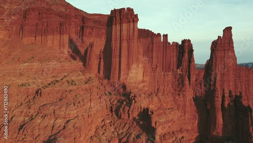 A high-flying drone shot over the grand Fisher Towers in Utah; The camera moves forward and rotates right toward the most extreme and tallest rock towers, the “King Fisher” and “The Titan