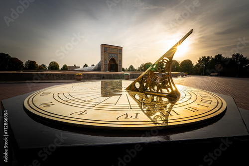 beautiful gilded sundial on a background of sunlight at sunset. old sundial showing the time