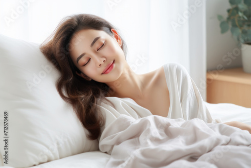 Happy Asian woman sleeping in cozy bed at home