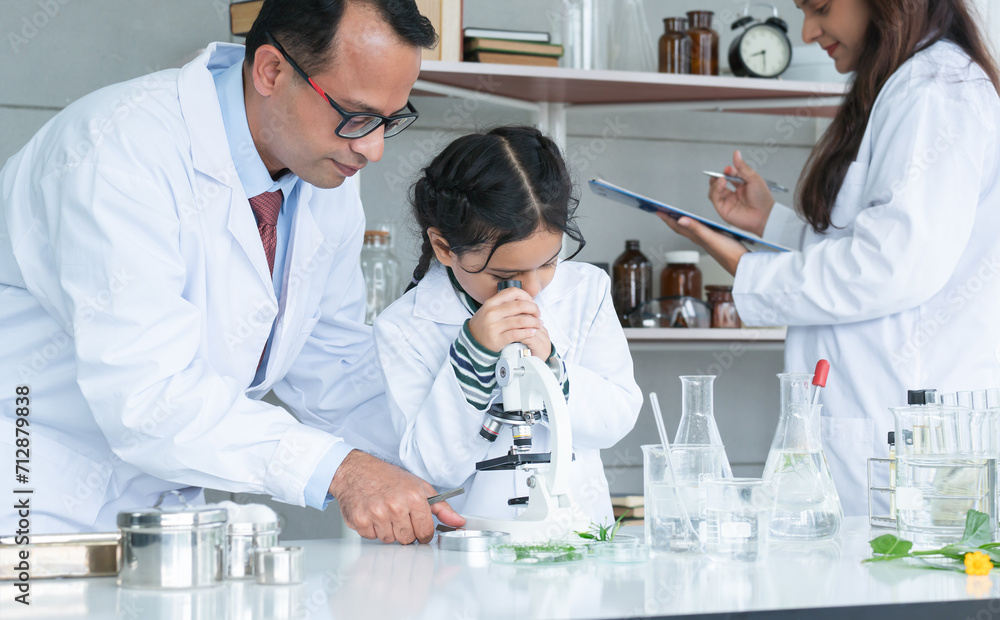 Asian scientist kid student and Indian teacher with plant at biology class in school laboratory, learning, teaching child girl to use microscope. Education, science and school concept Asian scientist kid student and Indian teacher with plant at biology class in school laboratory, learning, teaching child girl to use microscope. Education, science and school concept