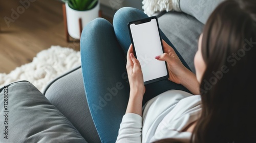 Woman on the couch using blank white screen smartphone. Generative AI. photo
