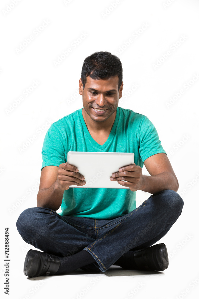 Happy Indian man using a tablet PC. Happy Indian man using a tablet PC.