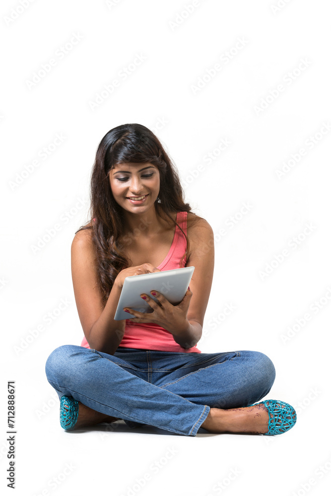 Young woman sitting on floor using a Digital Tablet PC. Young woman sitting on floor using a Digital Tablet PC.