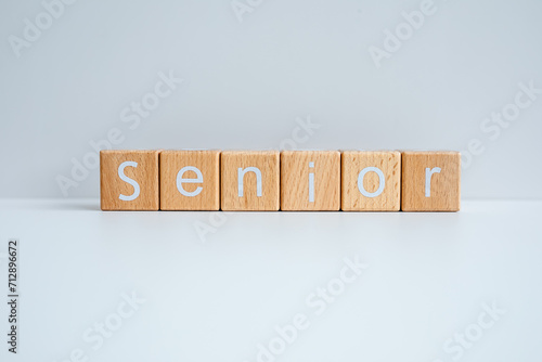 Wooden blocks form the text "Senior" against a white background.