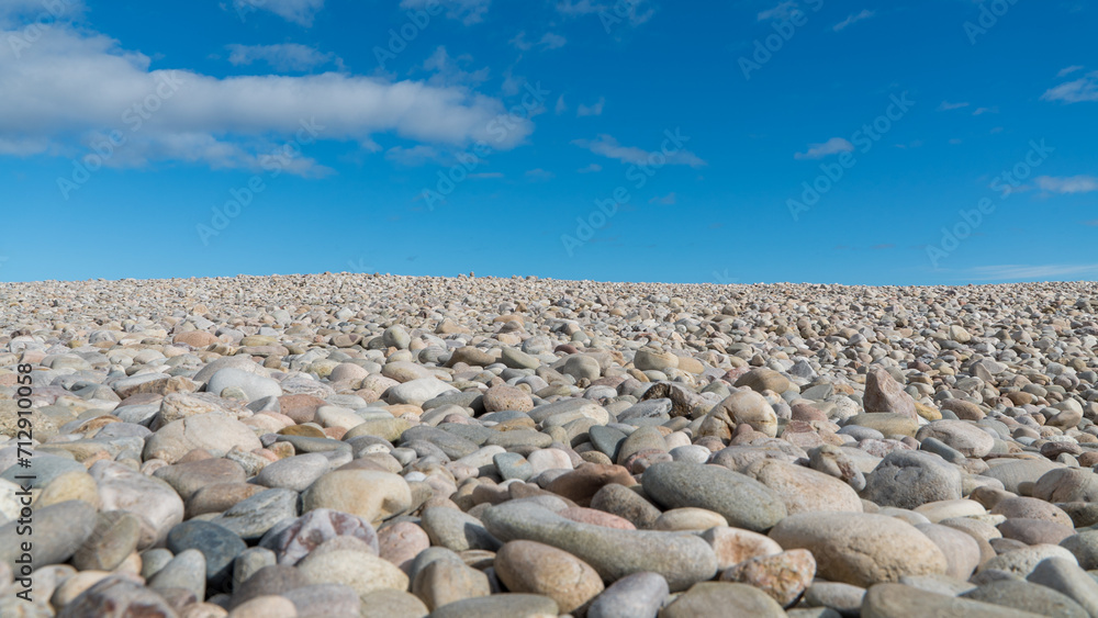 Pebbles on the beach with blue sky and light clouds on the coast of Scotland Pebbles on the beach with blue sky and light clouds on the coast of Scotland
