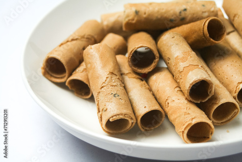 Crispy egg roll or crispy golden curl placed in a white plate, white background. Isolated.