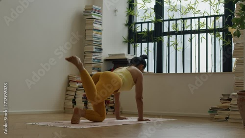 young asiatic woman in yellow sportswear doing morning workout exercise training in yoga , modern apartment lifestyle photo