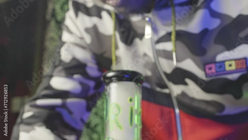 close up of a black man taking a hit of marijuana from a water bong and exhaling the smoke photo