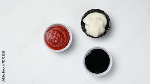 three sauces ketchup mayonnaise, sweet soy sauce and chili sauce in black bowl isolated on white background