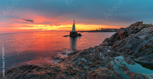 Solitude Radiance: Lone Lighthouse at Sunrise