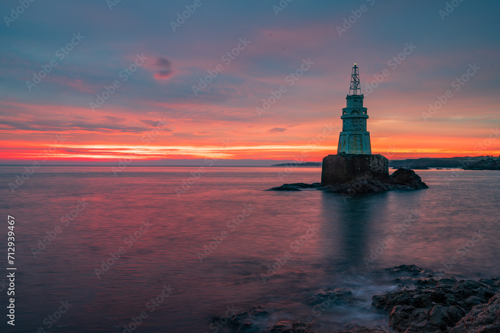 Solitude Radiance: Lone Lighthouse at Sunrise