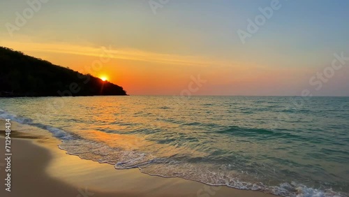 Beautiful Evening Seascape with Waves and Sun Setting over the Beach, Creating a Stunning Reflection on the Water, Surrounded by Clouds and a Tranquil Summer Sky