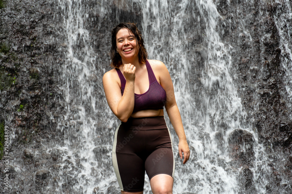 Young sporty woman looking at camera in waterfall background Young sporty woman looking at camera in waterfall background