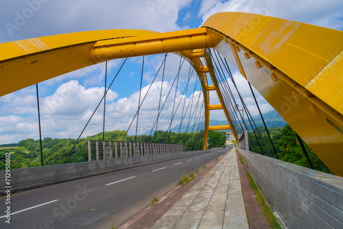 Niseko Bridge, the yellow bridge spanning across the Hakodate Main Line and Shiribetsu River, connecting the north and south of Niseko, Shiribeshi Subprefecture, Hokkaido, Japan photo