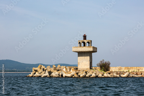 Old comcrete lighthouse in the sea photo