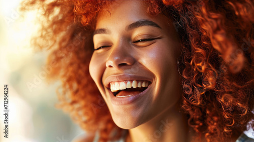 Joyful red-haired woman with freckles smiling broadly, showing her teeth. © MP Studio