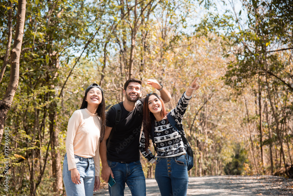 Happy Multi-ethnicity group of young friends enjoy hiking, walking, exploring in forest on vacation, female and man having fun in forest on beautiful autumn day, nature outdoor wild grass forest trip. Happy Multi-ethnicity group of young friends enjoy hiking, walking, exploring in forest on vacation, female and man having fun in forest on beautiful autumn day, nature outdoor wild grass forest trip.