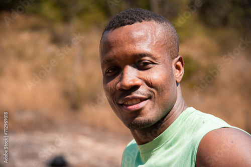 Close up of Happy african American man runner smiling after exercising, Healthy handsome living confidently and outdoors fitness. Fitness black man taking a break after running workout.