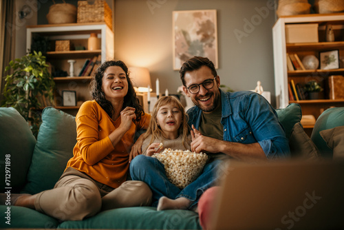 A family of three having a delightful time watching a film and snacking on popcorn